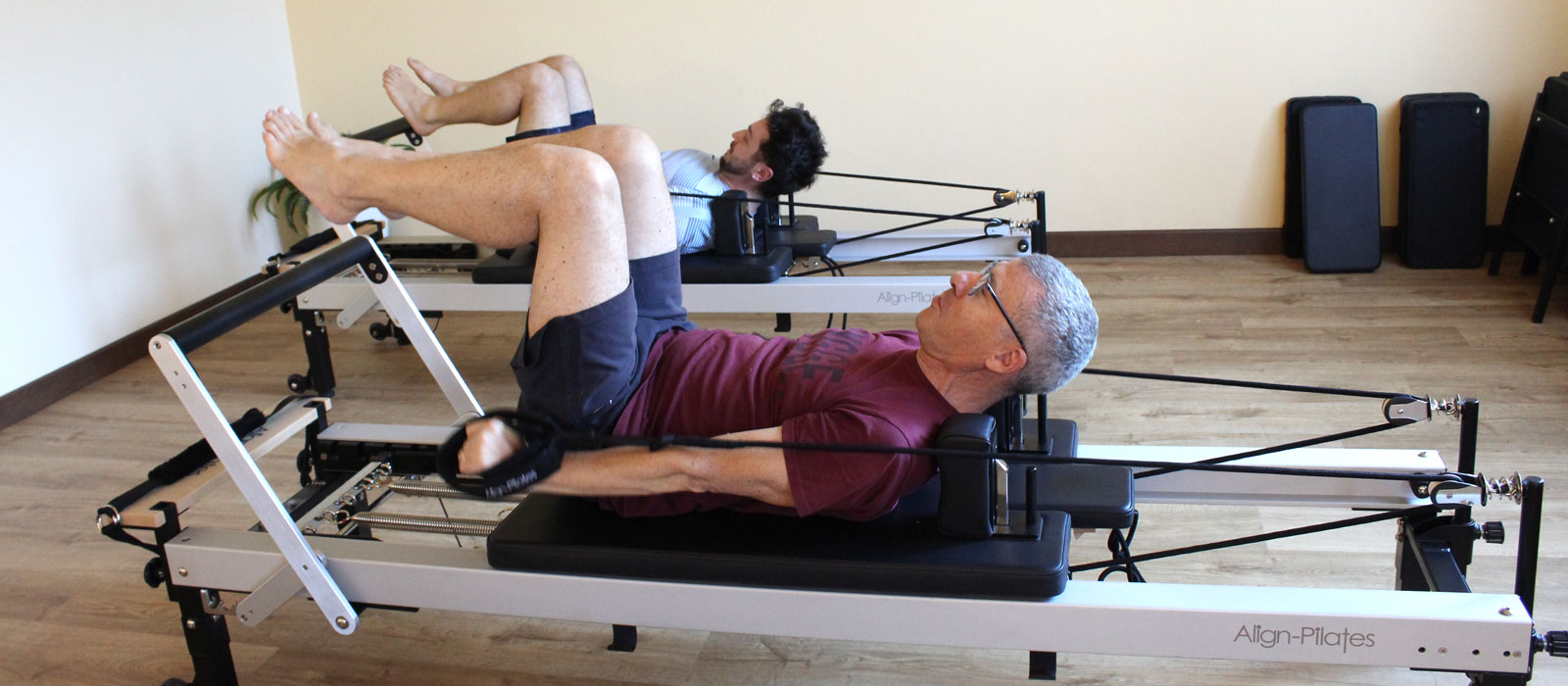 Coppia di adulti che eseguono esercizi di pilates reformer