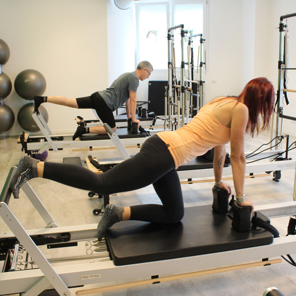 Coppia di persone che eseguono esercizi di pilates reformer a Seregno