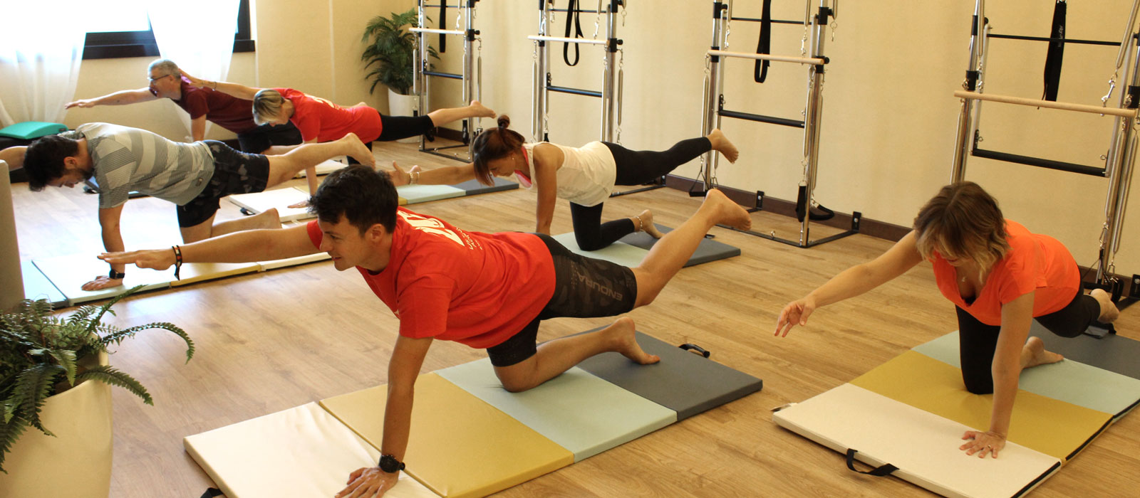 Gruppo di persone che eseguono esercizi di pilates a corpo libero a Carate Brianza