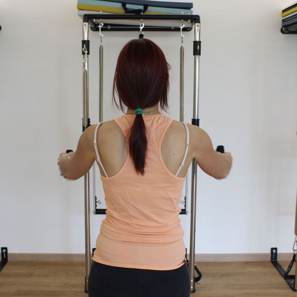 Donna di schiena che esegue pilates tower a Seregno e Carate Brianza