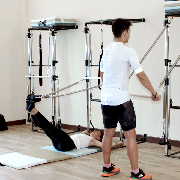 Gruppo di giovani mentre eseguono esercizi personalizzati alla postazione tower