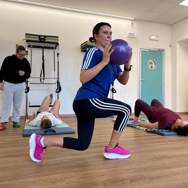 Donna che esegue squat con palla medica a Carate Brianza